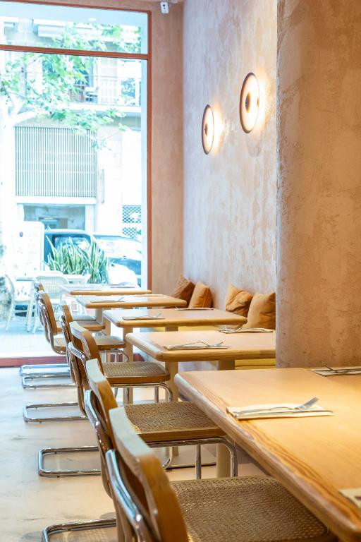 Sillas y mesas con un gran ventanal en el restaurante The Egg Lab del Hotel Constanza 